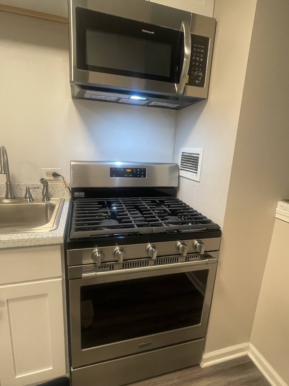 Clean kitchen with stainless range, microwave and countertop